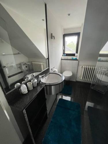 a bathroom with a sink and a toilet and a mirror at Zentrale Wohnung im Grünen! in Berlin