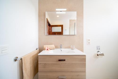 ein Bad mit einem Waschbecken und einem Spiegel in der Unterkunft Vaya Querida in Mala
