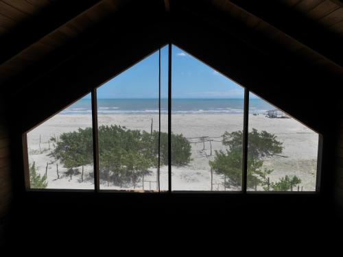 a window in a room with a view of the beach at Chalé a Beira Mar in Tatajuba