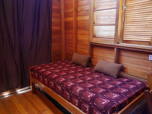 a small bed in a room with a window at Chalé a Beira Mar in Tatajuba