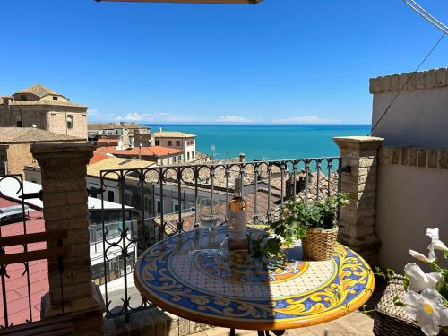 a table on a balcony with a view of the ocean at La Fabbrica di San Pietro Vasto in Vasto