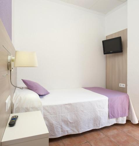 a hotel room with two beds and a tv at Hostal Adelino in San Antonio
