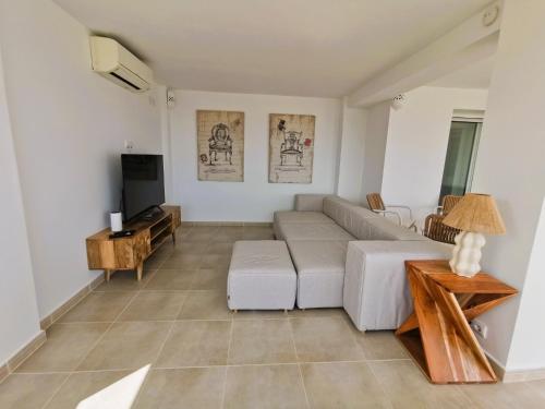 a living room with a white couch and a tv at Villa Panorama in Jávea
