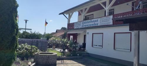 a building with a sign on the side of it at Gästehaus Grenzenlos in Aholfing