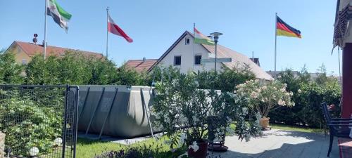 una casa con banderas volando en el patio en Gästehaus Grenzenlos, en Aholfing