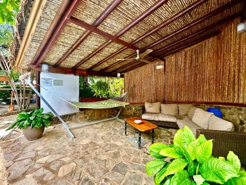 an outdoor patio with a hammock and a couch at Hotel Luna Llena in Tamarindo