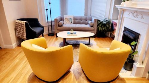 Sala de estar con 2 sillas amarillas y mesa en Sunny Victorian with Stunning View and Wraparound Deck en San Francisco