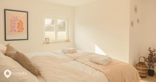 Un dormitorio blanco con una cama con toallas. en Naturoase Sinzing / Parkplatz, Waschmaschine, etc., en Sinzing