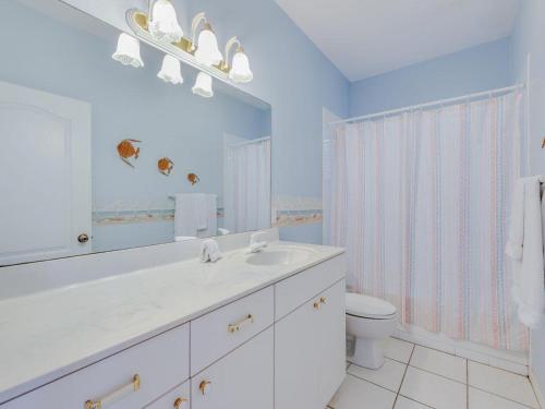 Baño blanco con lavabo y aseo en Villa Champagne - 5322, en Siesta Key