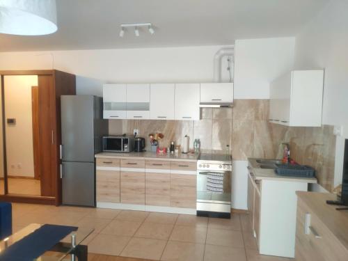 a kitchen with white cabinets and stainless steel appliances at Mieszkanie Suwałki in Suwałki