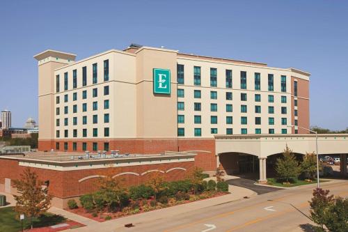 a large white building with a blue sign on it at Embassy Suites East Peoria Hotel and Riverfront Conference Center in Peoria