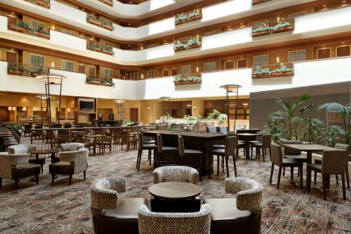 eine Hotellobby mit Tischen und Stühlen und eine Bar in der Unterkunft Embassy Suites East Peoria Hotel and Riverfront Conference Center in Peoria