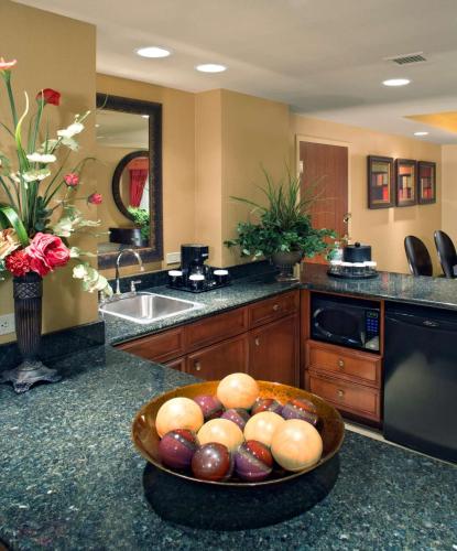 a kitchen with a bowl of fruit on a counter at Embassy Suites East Peoria Hotel and Riverfront Conference Center in Peoria