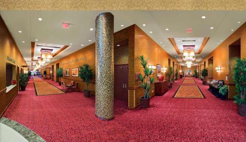 a hallway of a hotel with a red carpet at Embassy Suites East Peoria Hotel and Riverfront Conference Center in Peoria