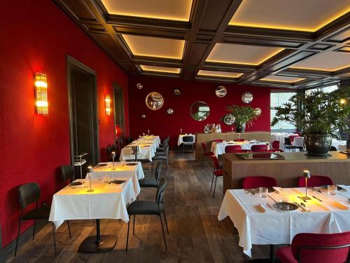 a restaurant with white tables and chairs and red walls at Le Funi Hotel in Bergamo