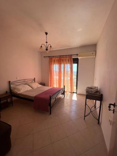 een slaapkamer met een bed en een groot raam bij Pounentis house in Messanagro