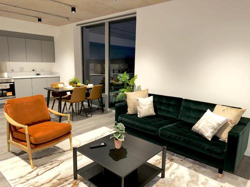 a living room with a green couch and a table at Stylish Apartment in Greenwich in Abbey Wood
