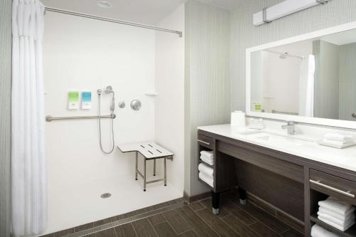 a bathroom with a sink and a shower with a mirror at Home2 Suites By Hilton Charlottesville Downtown in Charlottesville