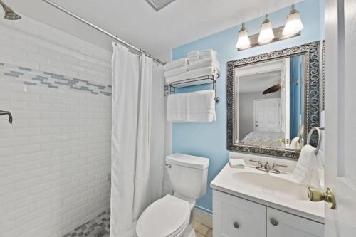 een badkamer met een toilet, een wastafel en een spiegel bij Honeysuckle - L in Siesta Key