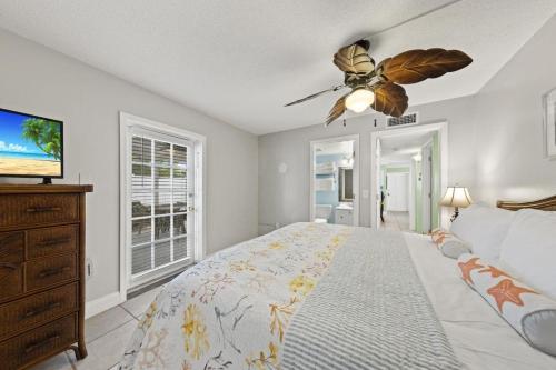 een slaapkamer met een bed en een plafondventilator bij Honeysuckle - L in Siesta Key