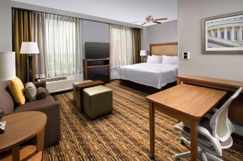 ワシントンにあるホームウッド スイーツ バイ ヒルトン ワシントンDC NoMa ユニオン ステーションのベッドとリビングルームが備わるホテルルームです。