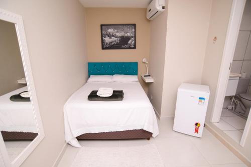 a small bedroom with a bed and a mirror at ASP hospedaria in Paranaguá