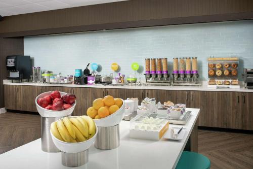 a table with bowls of fruit on top of it at Tru By Hilton Denver Airport Tower Road in Denver