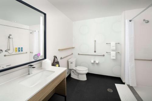 Tru By Hilton Denver Airport Tower Road في دنفر: حمام أبيض مع حوض ومرحاض