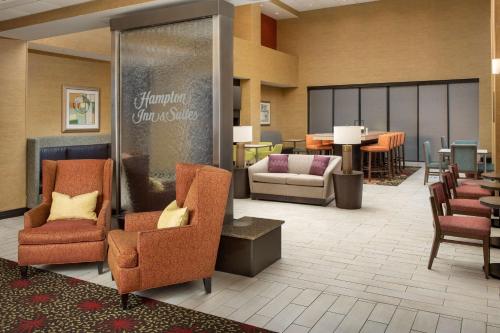 a lobby with chairs and a waiting area with tables at Hampton Inn & Suites Lakeland-South Polk Parkway in Lakeland