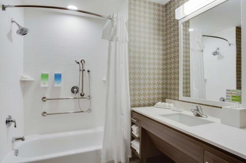 y baño con bañera, lavamanos y ducha. en Home2 Suites By Hilton Clermont en Clermont