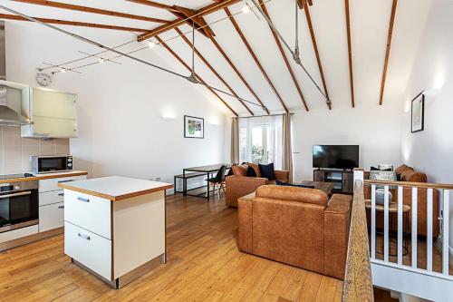 a kitchen and living room with a couch and a table at Light and airy upside down house in Boho Hackney in London