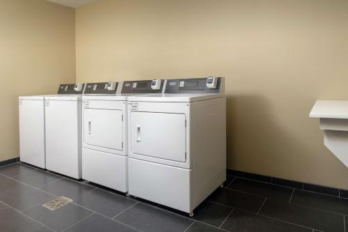 a row of white washers and dryers in a room at Tru By Hilton Lubbock Southwest in Lubbock