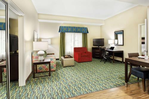 奧蘭多的住宿－奧蘭多機場希爾頓惠庭套房酒店，客厅配有红色椅子和书桌