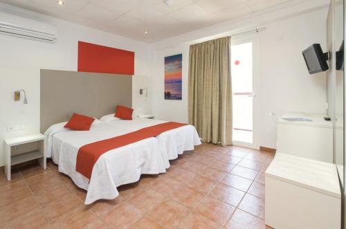 a hotel room with two beds and a television at Hostal Adelino in San Antonio