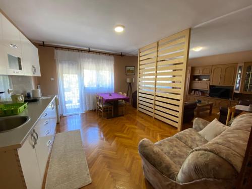 Drvar的住宿－Apartman Lavanda，厨房以及带沙发和桌子的客厅。