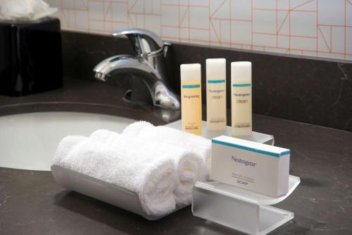 - un lavabo dans la salle de bains avec des serviettes et des brosses à dents sur un comptoir dans l'établissement Homewood Suites by Hilton Miami Downtown/Brickell, à Miami