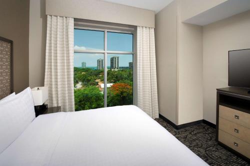 a bedroom with a bed and a large window at Homewood Suites by Hilton Miami Downtown/Brickell in Miami