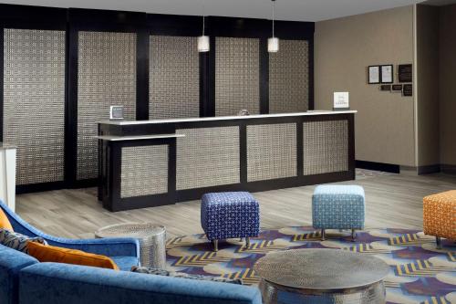 a waiting room with blue chairs and a counter at Homewood Suites by Hilton Metairie New Orleans in Metairie