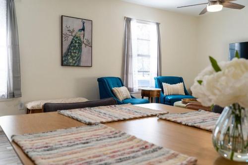 uma sala de estar com uma mesa e cadeiras azuis em Madrona's Cottage- Fully fenced and pet friendly em Charleston
