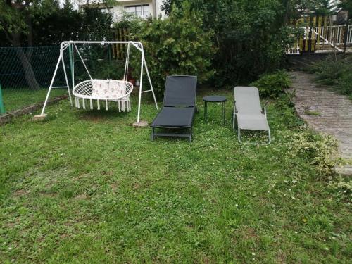 two chairs and a swing in a yard at Ari Villa Révfülöp in Révfülöp