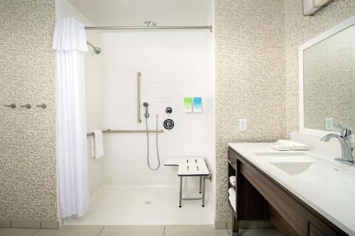 baño blanco con ducha y lavamanos en Home2 Suites By Hilton Phoenix Airport South en Phoenix