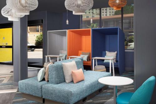 a blue couch in a room with tables and chairs at Tru By Hilton San Antonio Downtown Riverwalk in San Antonio