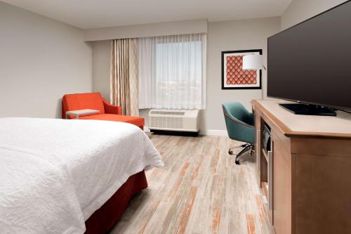 a hotel room with a bed and a flat screen tv at Hampton Inn & Suites San Antonio Lackland AFB SeaWorld in San Antonio