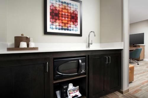 a kitchen with a sink and a microwave under a counter at Hampton Inn & Suites San Antonio Lackland AFB SeaWorld in San Antonio