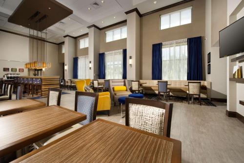 a dining room with tables and chairs and windows at Hampton Inn & Suites Falls Church in Falls Church