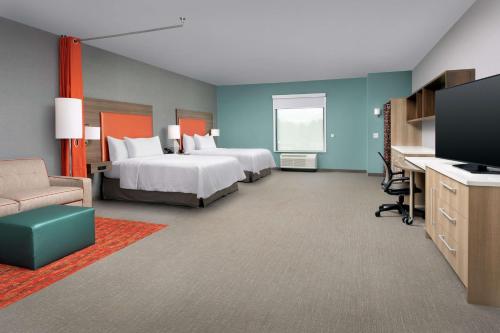 a hotel room with two beds and a desk at Home2 Suites By Hilton Asheville Biltmore Village in Asheville