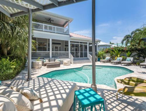 a swimming pool with chairs and a house at Isla Amor - 86 in Siesta Key