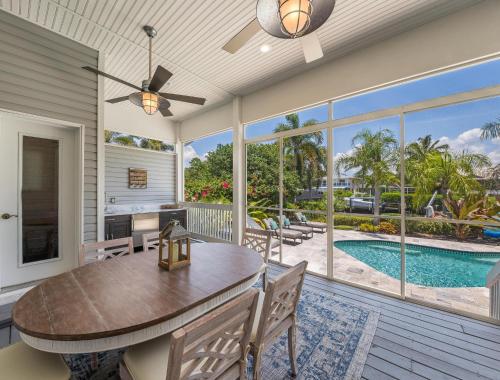 a dining room with a table and a view of a pool at Isla Amor - 86 in Siesta Key
