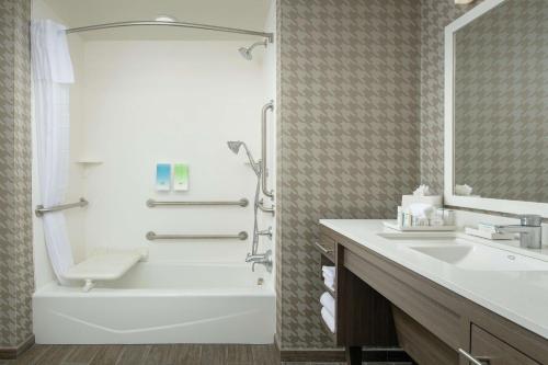 y baño con bañera, aseo y lavamanos. en Home2 Suites By Hilton Edison, en Edison