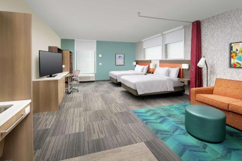 a hotel room with a bed and a television at Home2 Suites By Hilton Edison in Edison